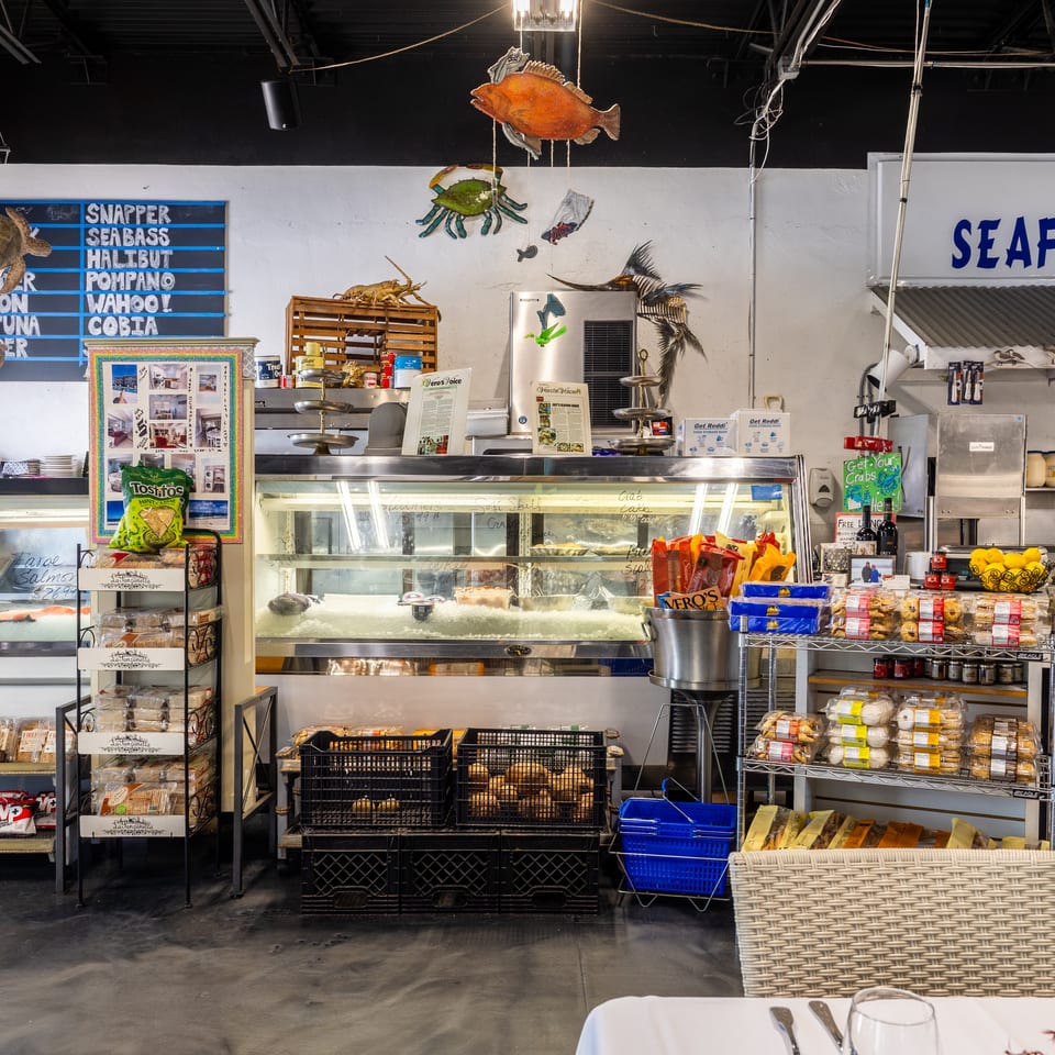 Interior of Joey's Seafood Shack, a fish market and restaurant, with fresh seafood displays and retail items.